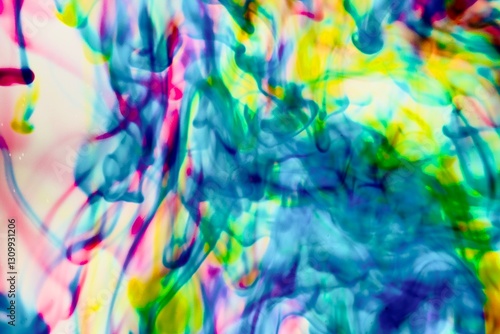 Abstract video with vibrant colors flowing with colored inks dispersed in water. The composition consists of shades of blue, red, green and yellow blending and swirling on a light background, creating