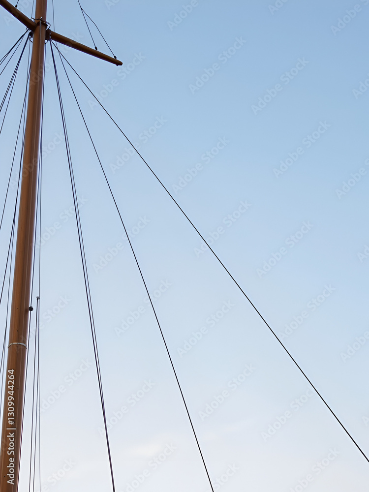 Sailing ship mast with rigging and cables against the sky. Sailing ship mast with rigging and cables against the sky.
