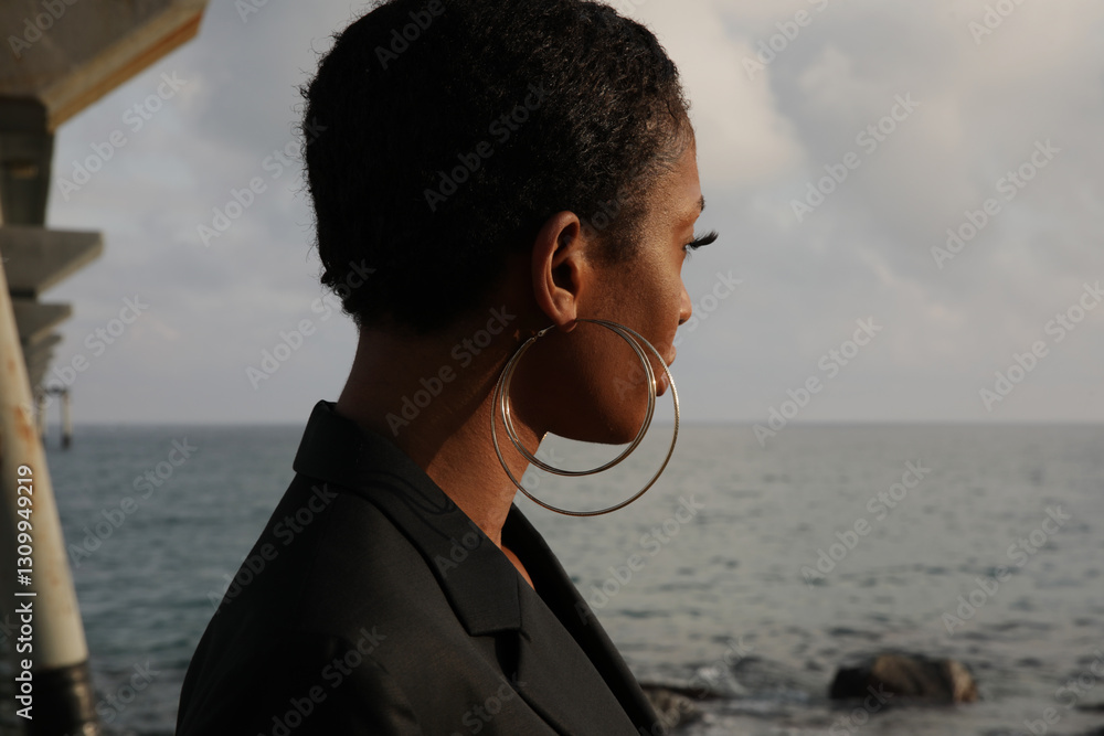 Side portrait of young African American woman with short hair cut. Outdoor. Side portrait of young African American woman with short hair cut. Outdoor.