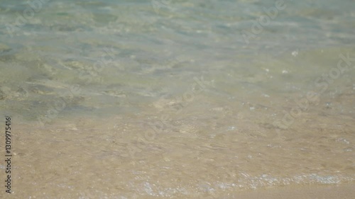 Experience the soothing sound and feel of warm waves gently meeting the sandy beach along the stunning coastline of the Aegean Sea in Greece.