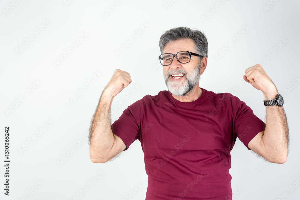 Fototapeta premium Mature handsome man with beard wearing casual t-shirt and glasses over grey background very happy and excited doing winner gesture with arms raised, smiling and screaming for success.