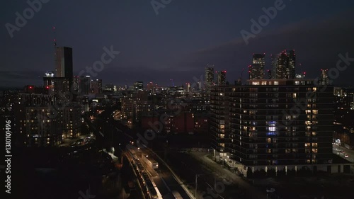 A stunning evening view of Deansgate Square in Manchester, showcasing illuminated urban architecture and transportation. This scene captures the charm of the city transitioning into night.