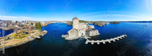 Beautiful aerial view of Olavinlinna, Olofsborg ancient fortress, the 15th-century medieval three - tower castle located in Savonlinna city on a sunny summer day, Finland. Shooting from a quadcopter.