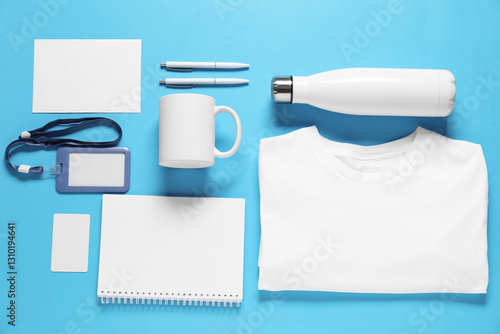 Different blank items for branding on light blue background, flat lay. Mockup for design