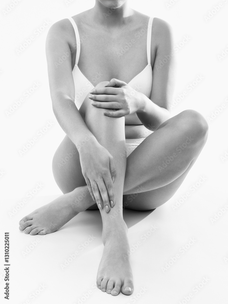 Naklejka premium A slender swarthy woman in white underwear on a white cosmetology room. Healthy lifestyle, sport and diet.