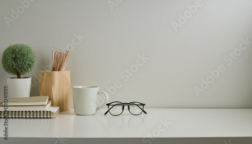 desk with stationery, eyeglasses, notebook, mug and a plant, copy space