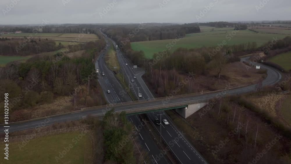 Explorative aerial overview drone flight over motorway traffic busy roads in England UK rush hour cars trucks vehicles tarmac highway Explorative aerial overview drone flight over motorway traffic busy roads in England UK rush hour cars trucks vehicles tarmac highway