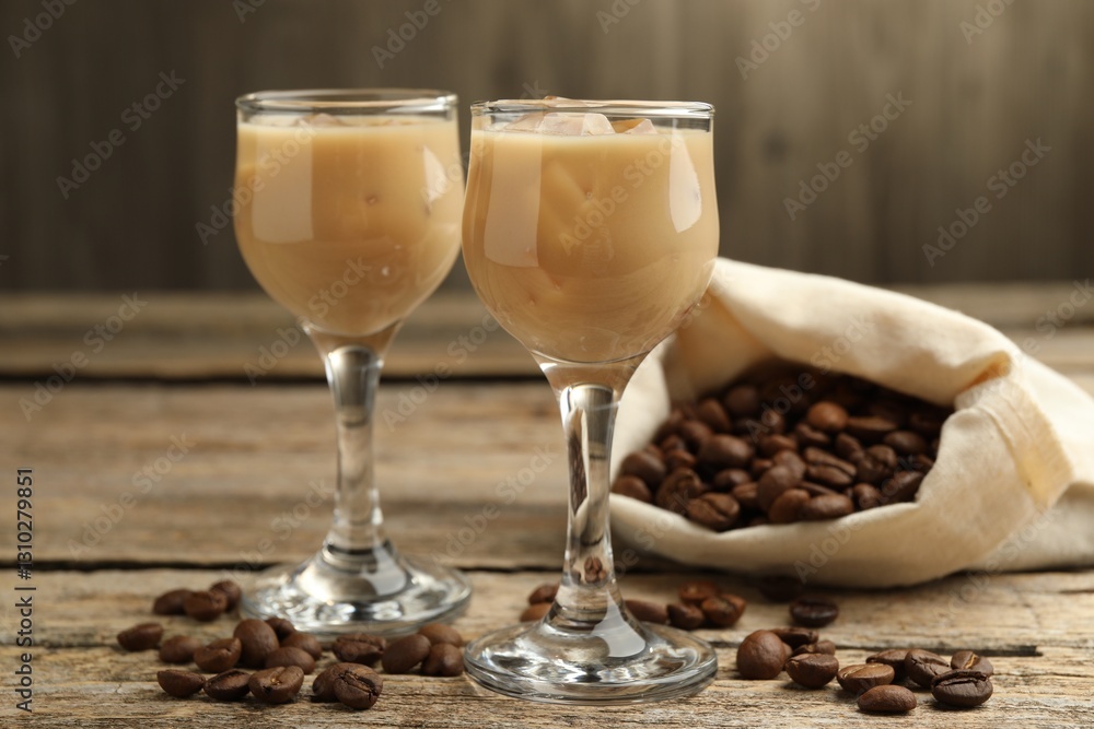 Coffee cream liqueur in glasses and beans on wooden table, closeup Coffee cream liqueur in glasses and beans on wooden table, closeup