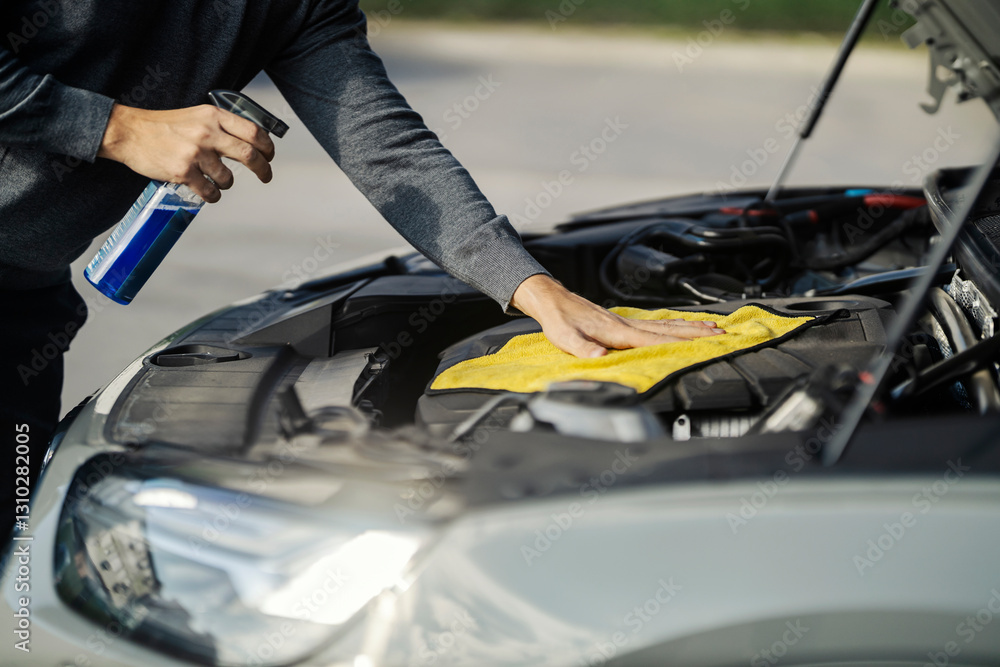 © Dusan Petkovic - A man is cleaning car under the hood with microfiber cloth and sprayer.