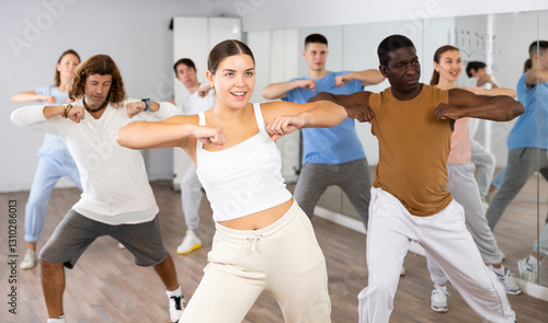 Canvas Print Big group of young adult fit people in activewear exercising together during tra