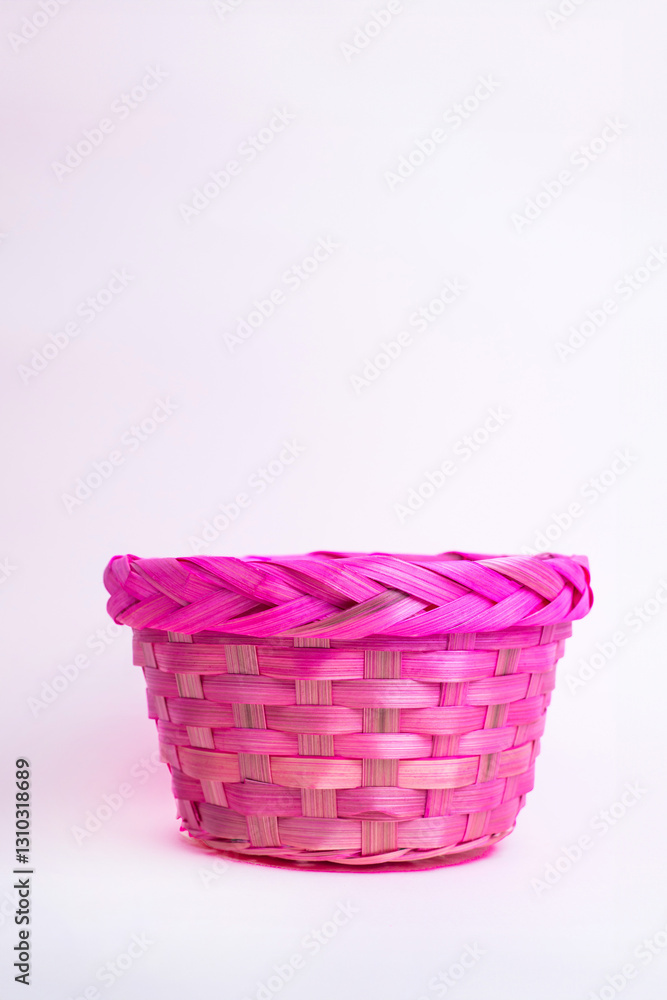 A handcrafted pink wicker basket sits against a pastel pink background. Its bold color and woven texture make it ideal for Easter, spring décor, seasonal crafts, or festive gift presentations. A handcrafted pink wicker basket sits against a pastel pink background. Its bold color and woven texture make it ideal for Easter, spring décor, seasonal crafts, or festive gift presentations.