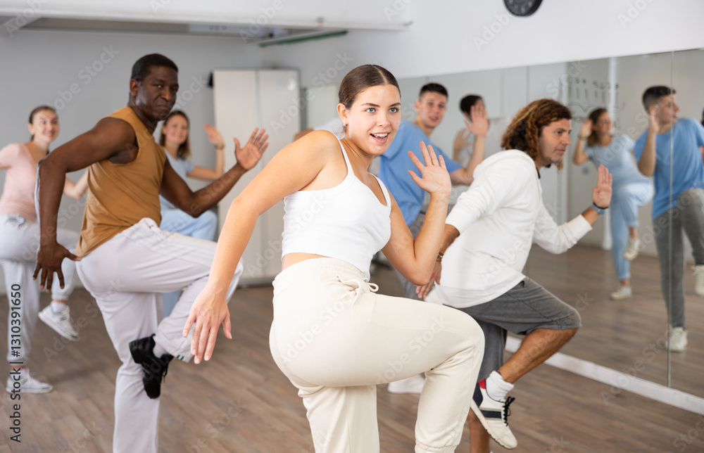 Fototapeta premium Group of active women and men practicing energetic dance in a modern dance studio