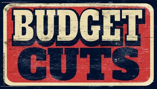 Aged and worn budget cuts sign on wood