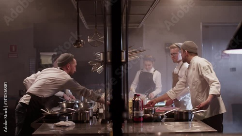 Chefs preparing food in commercial kitchen restaurant