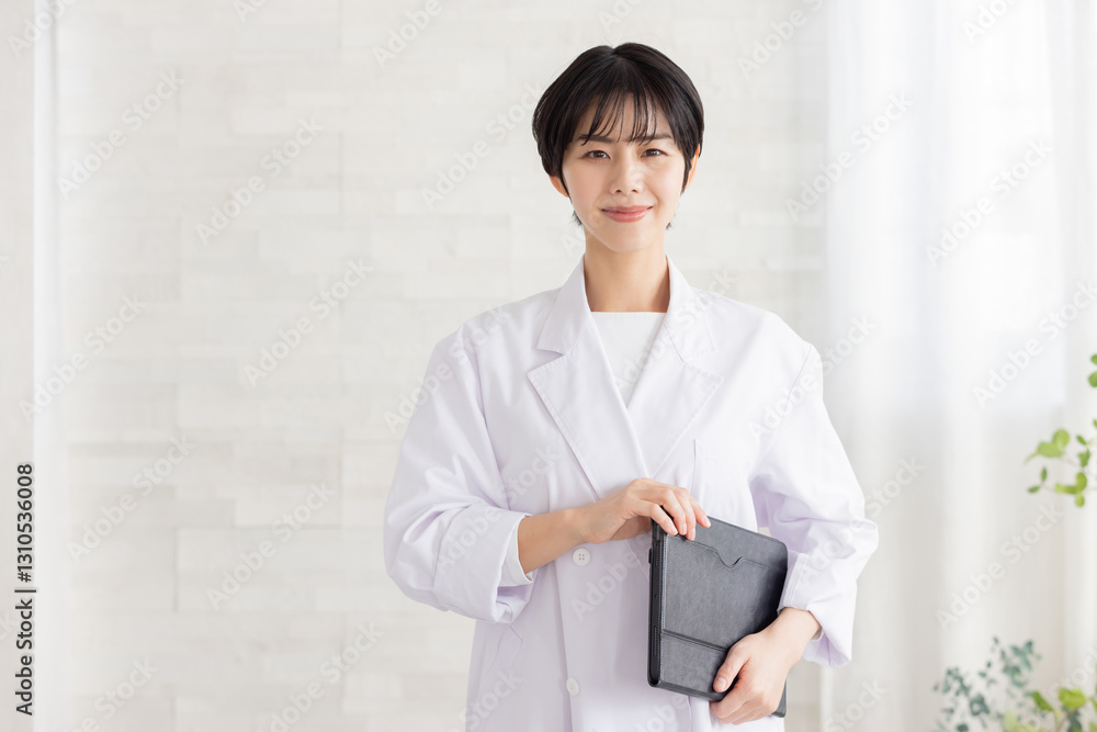 タブレットを持つ白衣の女性医師
タブレットを持つ白衣の女性医師