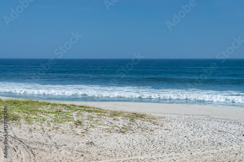 Wallpaper Mural Partial view of Praia Seca beach shoreline of calm Atlantic Ocean blue waters breaking on white sands under summer afternoon clear blue sky in Praia Seca district, Araruama, Rio de Janeiro - Brazil. Torontodigital.ca