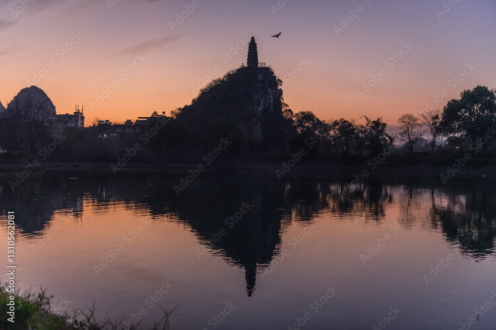Obraz premium Pagoda and the city buildings surrounded by the limestone mountains