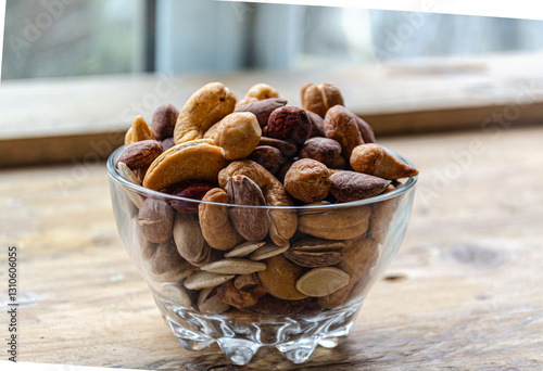 Assorted nuts in glass bowl on kitchen table