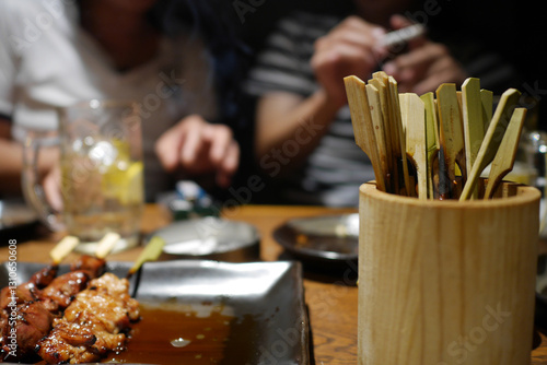 友達と焼き鳥を食べながら晩酌をする