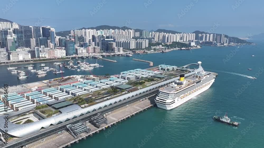 Drone aerial skyview of a mega luxury cruise ship sailing at the Kai Tak cruise terminal, showcasing the vibrant Victoria Harbour and the iconic city skyline of Kwun Tong Kowloon Hong Kong Drone aerial skyview of a mega luxury cruise ship sailing at the Kai Tak cruise terminal, showcasing the vibrant Victoria Harbour and the iconic city skyline of Kwun Tong Kowloon Hong Kong
