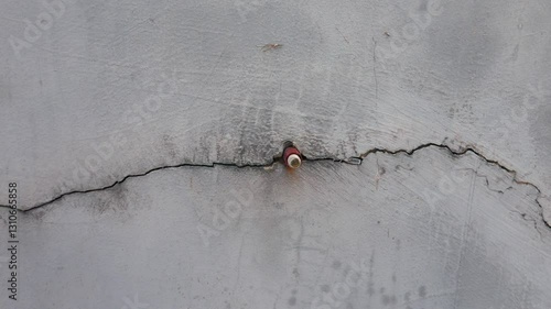 single line crack in the wall, nail stuck in the wall.