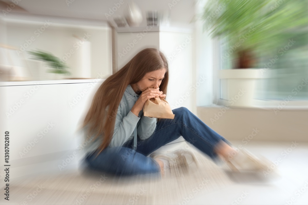Young woman with paper bag having panic attack in kitchen Young woman with paper bag having panic attack in kitchen