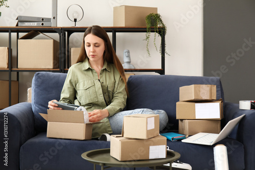 Young woman packing parcel ...