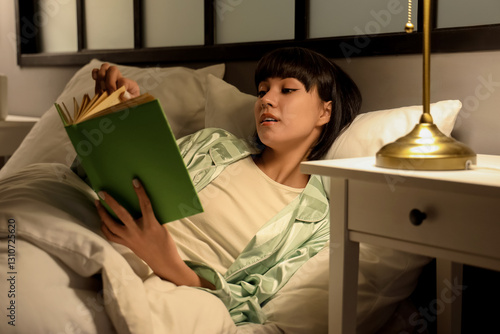 Young woman reading book in...