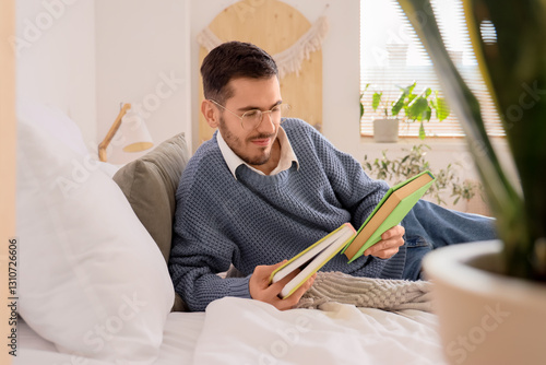 Young man with books lying ...