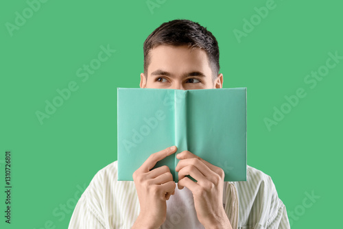 Young man with book on gree...