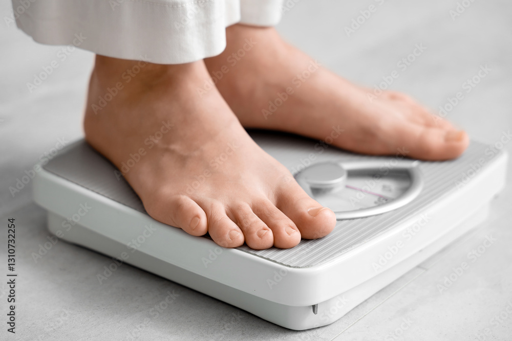 Fototapeta premium Young woman standing on scales at home, closeup. Weight loss concept