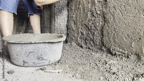 Footage of closeup worker applying decorative concrete plaster on the wal