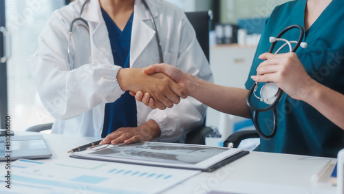 Wallpaper Mural Two Asian female doctors shake hands after a successful meeting at a hospital, celebrating cooperation between two hospitals and recognizing their teamwork in advancing healthcare and patient care Torontodigital.ca