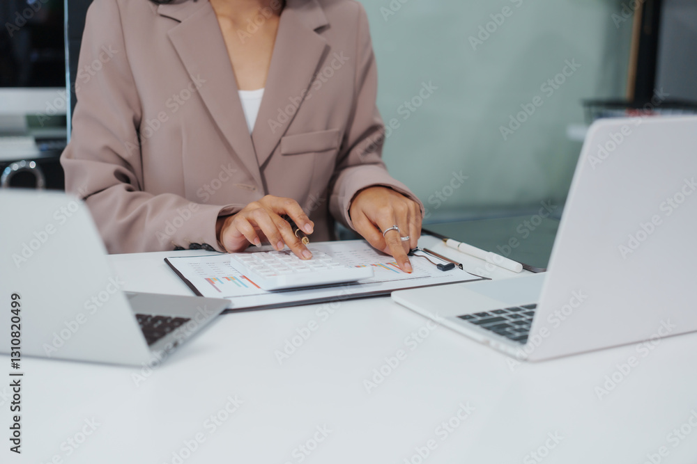 An Asian businesswoman accountant calculates invoices, taxes, interest, loans using a calculator,working online to guide clients through financial planning ensure a smooth loan process for success An Asian businesswoman accountant calculates invoices, taxes, interest, loans using a calculator,working online to guide clients through financial planning ensure a smooth loan process for success