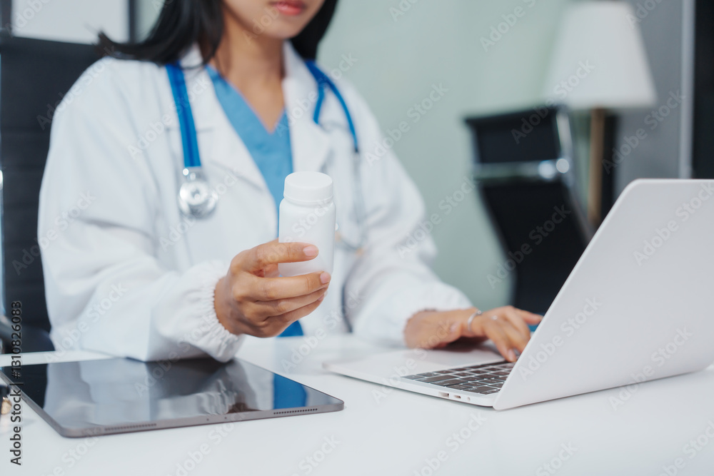Asian female doctor is reviewing medical records, working on a computer, planning treatment, giving online consultations, and explaining medications to patients via a medical video call in a clinic Asian female doctor is reviewing medical records, working on a computer, planning treatment, giving online consultations, and explaining medications to patients via a medical video call in a clinic