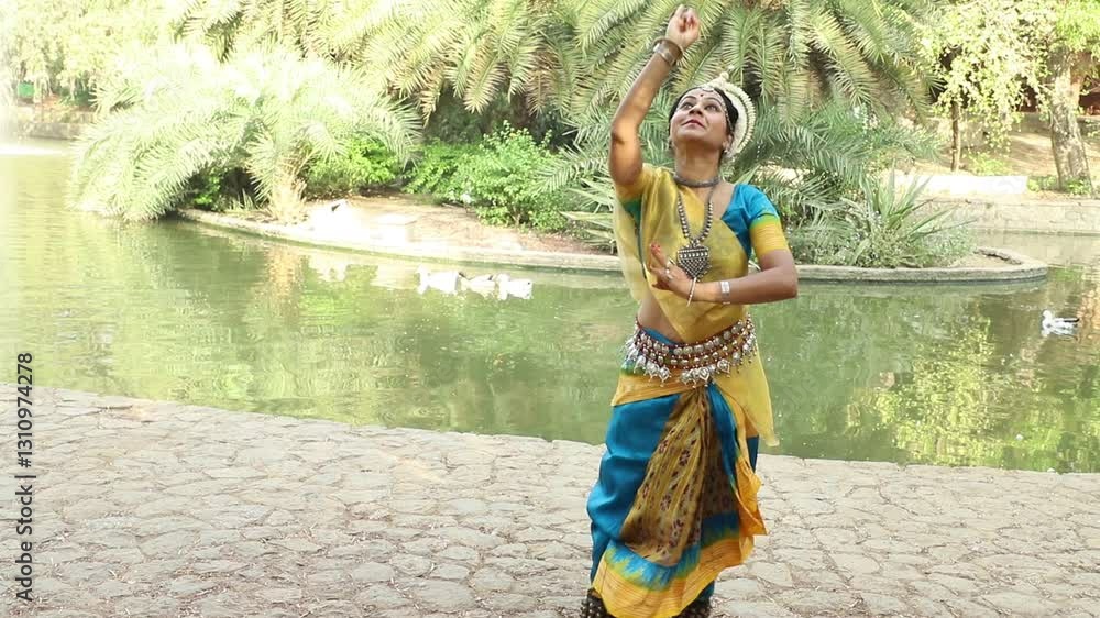 Indian woman Odissi dancer doing classical dance form outdoor at nature park. Orissi dance. art and culture of india. Female artist performing.