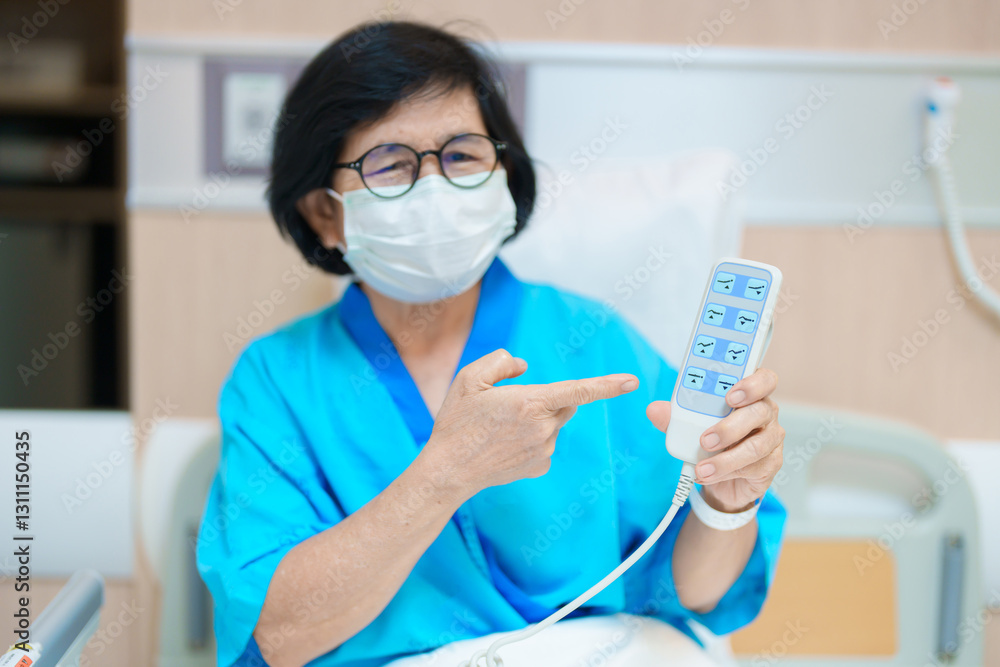 Elderly asian Woman patient hand using remote control for adjust level bed in hospital room. Happy Senior illness resting on comfortable electric bed in modern hospital Elderly asian Woman patient hand using remote control for adjust level bed in hospital room. Happy Senior illness resting on comfortable electric bed in modern hospital