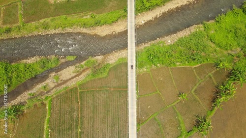 Aerial View of a Rural Bridge Spanning Over a River and Rice Fields