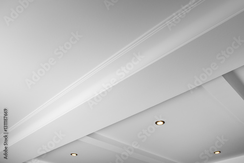 Suspended and grid ceiling with LED spots lamps and drywall construction in empty room in house interior. Stretch ceiling white and complex shape.