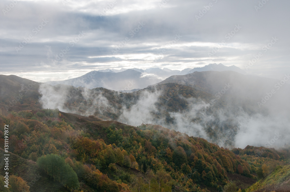 Picturesque silhouettes of the Caucasus mountains covered in fog on the sunrise during autumn, Adygea, Russian Federation Picturesque silhouettes of the Caucasus mountains covered in fog on the sunrise during autumn, Adygea, Russian Federation