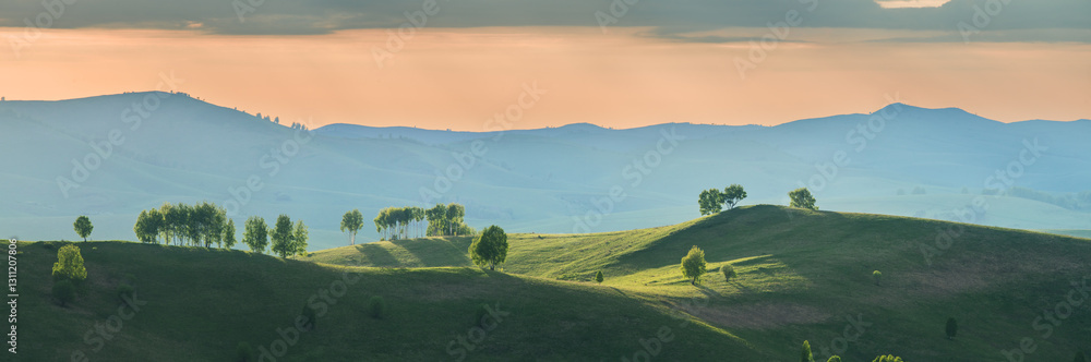 Fototapeta premium Evening rural landscape, the setting sun, sunset, meadows and hills 