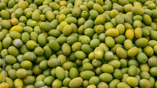 Background of green olives with smooth shiny surfaces natural shades of yellow and light green create a vibrant and organic texture