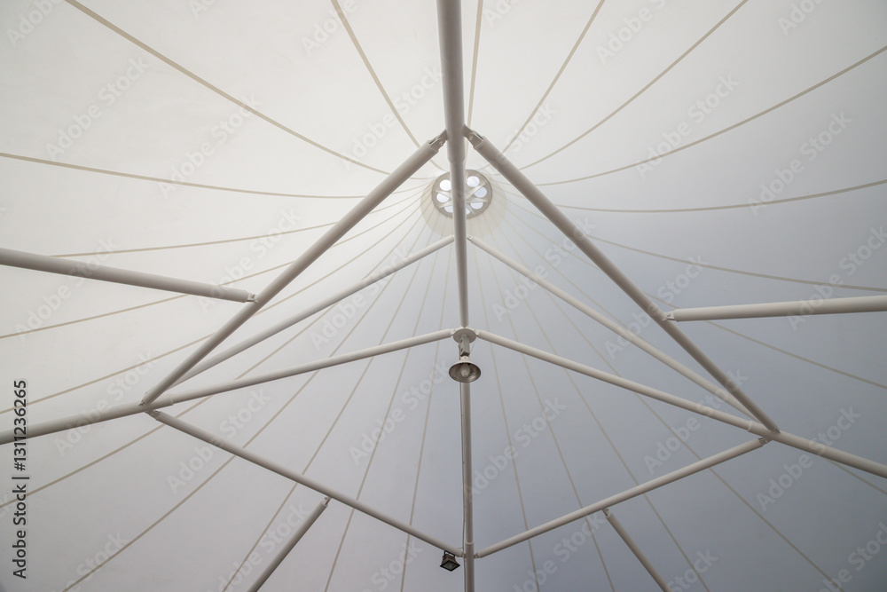 The white tent has a triangular shape and is covered in white fabric The white tent has a triangular shape and is covered in white fabric
