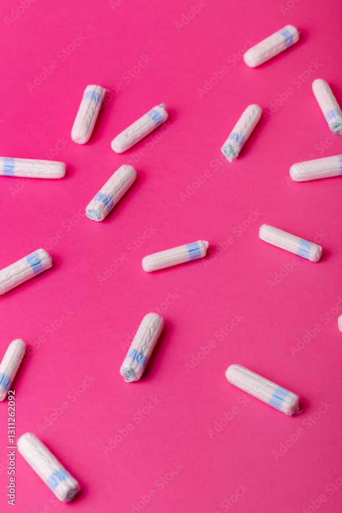 Many menstrual hygiene tampons from above on pink background. Soft cotton absorbent menstrual tampons for women during menstruation. Feminine hygiene. Many menstrual hygiene tampons from above on pink background. Soft cotton absorbent menstrual tampons for women during menstruation. Feminine hygiene.