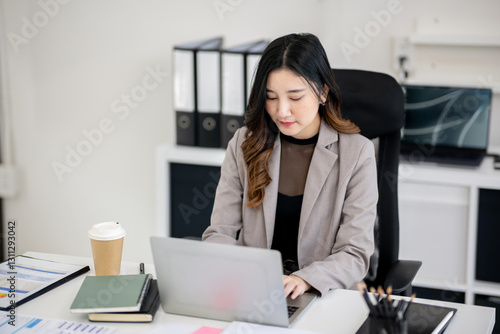 Asian female employee is sitting and working in an office.