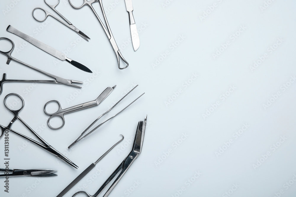 Different surgical tools on light gray background, flat lay. Space for text Different surgical tools on light gray background, flat lay. Space for text