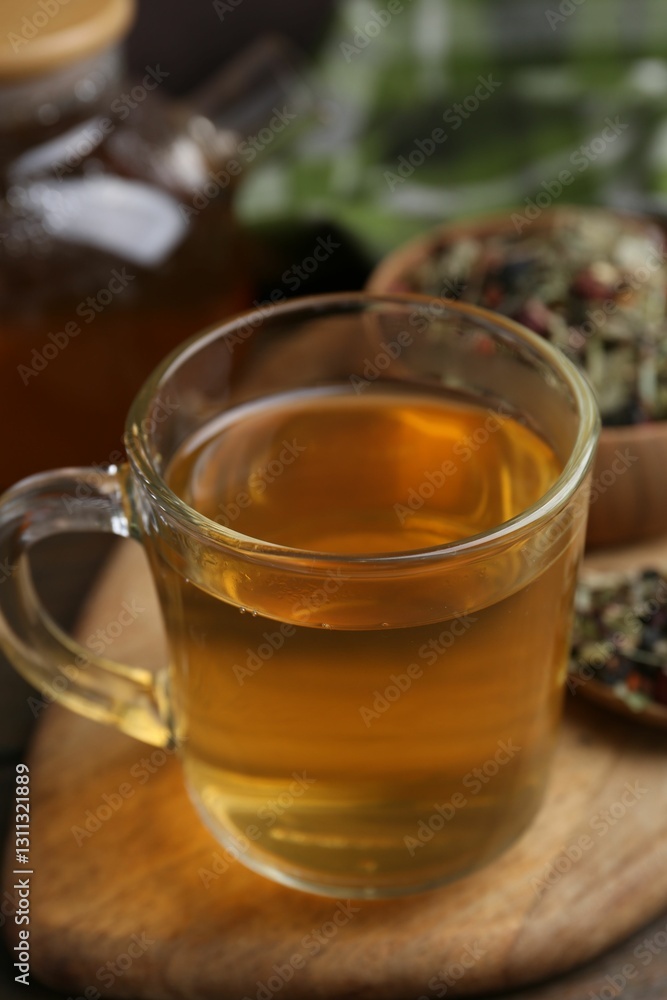 Delicious herbal tea and dry leaves on wooden table, closeup Delicious herbal tea and dry leaves on wooden table, closeup