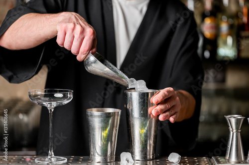 Foto A bartender skillfully prepares a cocktail using a shaker, ice, and a glass, showcasing the art of mixology in a stylish bar setting