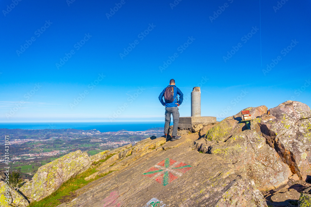 Obraz premium A male hiker on the top of Mount Adarra in Urnieta. Gipuzkoa, Basque Country