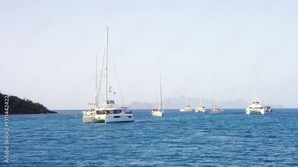 Catamarans and sailboats on the tropical water of Tobago Cays in the Grenadines Catamarans and sailboats on the tropical water of Tobago Cays in the Grenadines